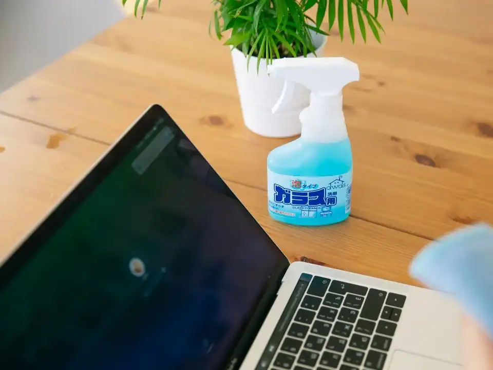 Limpieza de oficinas en Barakaldo: técnico desinfectando teclados y pomos junto al office de la empresa